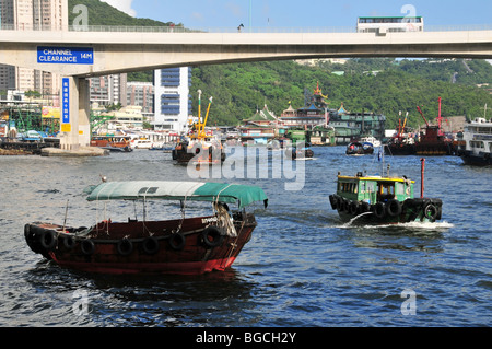 Sampan barca da pesca passando un turista sampan, ormeggiata vicino all'Ap Lei Chau Bridge, Aberdeen Harbour, Hong Kong, Cina Foto Stock