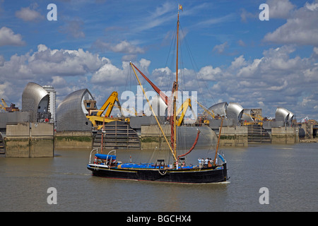 Barca a vela passando attraverso Thames Barrier, Londra, Inghilterra Foto Stock