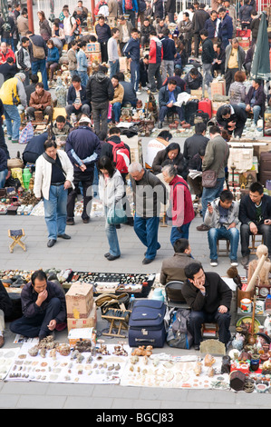 I fornitori che vendono i loro prodotti sul terreno al mercato di sporco anche il nome di Panjiayuan Mercato di Antiquariato a Beijing in Cina Foto Stock