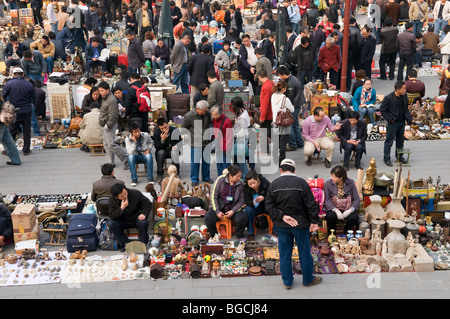 I fornitori che vendono i loro prodotti sul terreno al mercato di sporco anche il nome di Panjiayuan Mercato di Antiquariato a Beijing in Cina Foto Stock