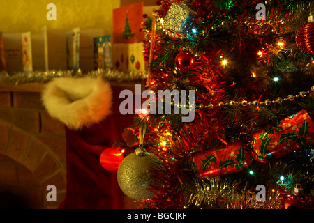 decorated christmas tree on christmas eve night in a living room in the uk Foto Stock