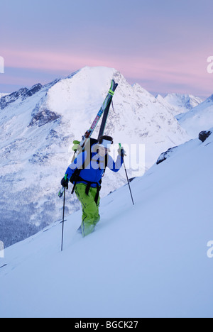 Rosa tenue e blu artico luce midwinter vicino a mezzogiorno, sciatore salendo Andersdalstinden montagna vicino a Tromsoe, Norvegia settentrionale Foto Stock