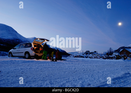 Gli sciatori in dintorni di luna auto disimballaggio e preparazione per una giornata in montagna, Tamokdalen, arctic Norvegia Foto Stock