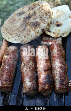 Barbecue. "Sis kebab", carni macinate rotoli la tostatura su hot barbeque piastra con "somun" pane tagliato in due. Foto Stock