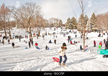 I bambini e i genitori con la slitta e di divertirsi sulla neve in Cedar Hill nel Central Park di New York, Stati Uniti d'America, 20 dicembre 2009. Foto Stock