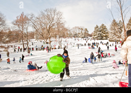 I bambini e i genitori con la slitta e di divertirsi sulla neve in Cedar Hill nel Central Park di New York, Stati Uniti d'America, 20 dicembre 2009. Foto Stock