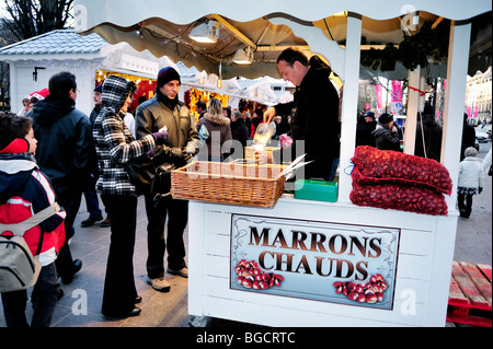 Parigi, Francia, folla, shopping gastronomico natalizio, coppia che acquista castagne arrosto al tradizionale mercato francese, venditore ambulante Foto Stock