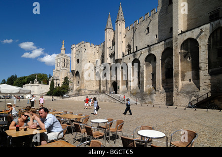 I turisti al Sidewalk Cafe o Pavement Cafe di fronte al Palais des Papes o Palazzo dei Papi, Place du Palais, Avignone, Provenza Francia Foto Stock