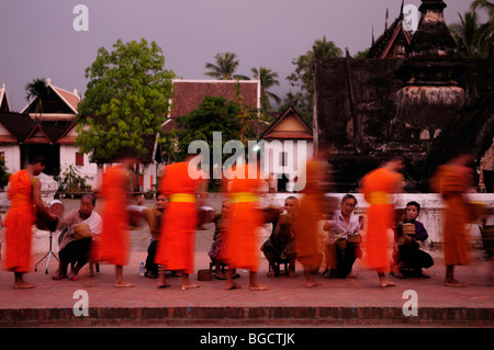 Laos; Luang Prabang; monaci raccogliendo elemosine all'alba Foto Stock