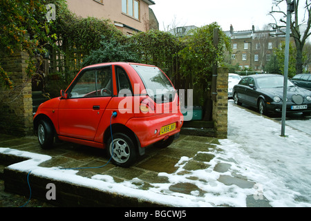 G Wiz GWiz G-Wiz pulita batteria verde con motore elettrico veicolo auto parcheggiate in strada residenziale road spazio parcheggio drivew privato Foto Stock