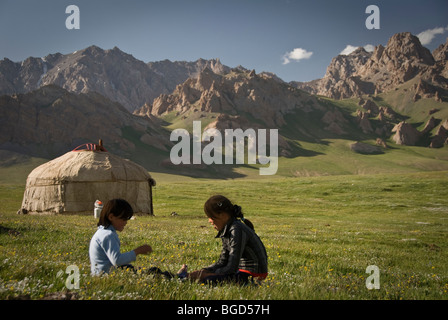 I bambini del Kirghizistan giocando sull'erba, Irkestan Pass, Kirghizistan Foto Stock