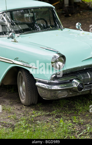 La parte anteriore di una luce blu Pontiac classic, messa a fuoco sul faro e ruota anteriore. Foto Stock