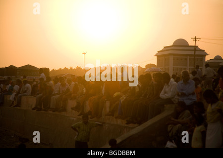 Le persone si radunano per godersi la fine bagliore del sole pomeridiano e al tramonto a Kanyakumari (Capo Cormorin) in India. Foto Stock