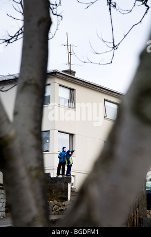 Due ragazzi al di fuori della loro casa. Hafnarfjordur, una maggiore area di Reykjavik, a sud-ovest dell'Islanda. Foto Stock