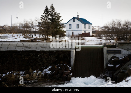 Casa residenziale accanto ad una piccola diga. Hafnarfjordur, una maggiore area di Reykjavik, a sud-ovest dell'Islanda. Foto Stock