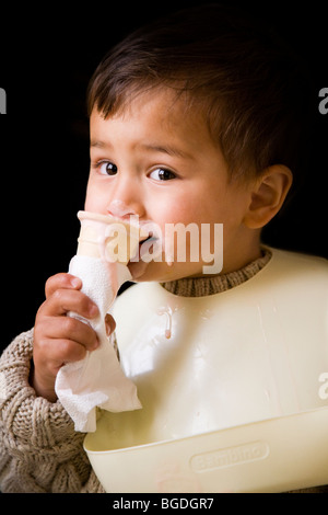 21 mesi o. boy mangiare gelato da un cono. Foto Stock