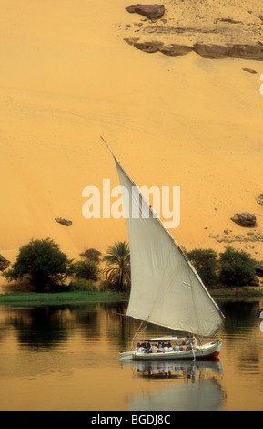 Feluca, egiziane barca a vela di fronte al deserto del Sahara. Nilo ad Aswan con fellucca e deserto. Aswan. L'Egitto. L'Africa. Foto Stock