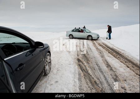 Lo scavo di una vettura al di fuori della neve nelle valli gallesi che circonda Elan Valley e Rhayader. Condizioni meteorologiche estreme in inverno. Foto Stock