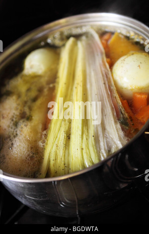 In casa brodo vegetale con sedano cipolle Carote svedese e patate bollendo lentamente nel recipiente di cottura Foto Stock