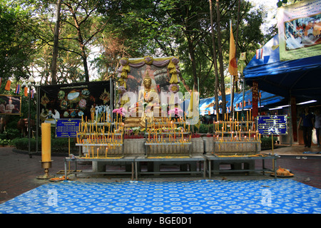 Oro statua del Buddha santuario con candele, Bangkok, Thailandia. Foto Stock