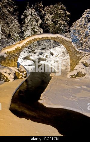 Il Packhorse Bridge a Carrbridge illuminate in inverno la neve Strathspey Inverness-shire Highland scozzesi. SCO 5722 Foto Stock