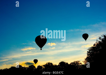 Tre mongolfiere stagliano contro il cielo di sera in Barneveld, Olanda, in corrispondenza di un balloon festival Foto Stock