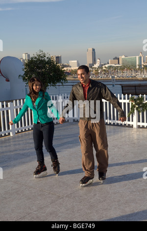 Paio di pattinaggio su ghiaccio su una pista di ghiaccio sintetico a bordo della Queen Mary hotel e attrazioni a Long Beach, CA Foto Stock