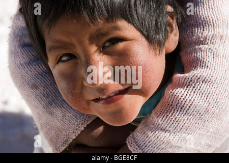 Ragazzo giovane essendo abbracciato da sua sorella nei pressi di saline Salar de Uyuni in S.W. Bolivia, S.America Foto Stock