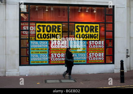 Negozio finestra segni la notifica della chiusura dello store in giù e stock liquidazione nel segno dei tempi Foto Stock