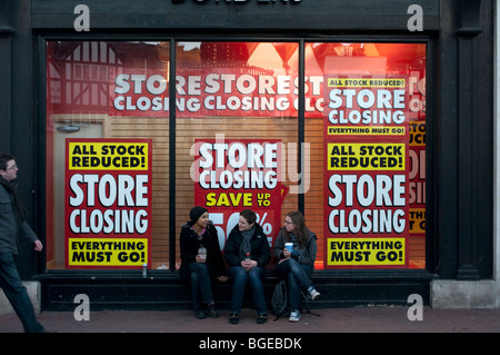 Negozio finestra segni la notifica della chiusura dello store in giù e stock liquidazione nel segno dei tempi Foto Stock