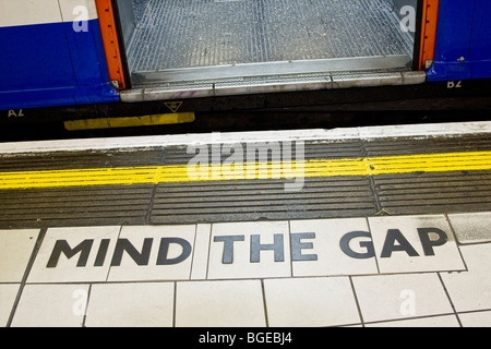 Mente il divario segno tra il treno e una piattaforma nella metropolitana di Londra. Foto Stock