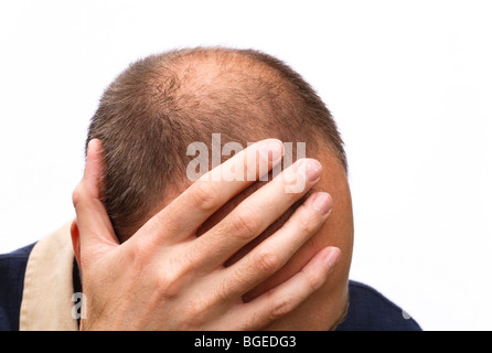 Uomo che esprimono lo stress, preoccupazioni o depressione; isolata contro uno sfondo bianco Foto Stock