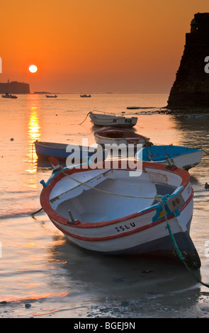 Piccole barche da pesca ancorate a Playa de la caleta al tramonto nella città di Cadice, provincia di Cadice, Costa de la Luz, Andalusia Foto Stock