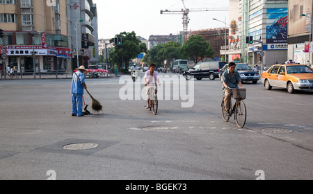 I ciclisti e pulitore di via di Shanghai Foto Stock