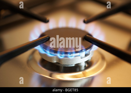 Il gas naturale corona bruciatore acceso sul piano di cottura per cucina Foto Stock