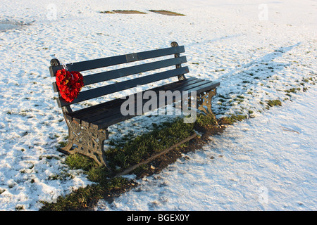 Una corona di fiori collocato su un banco di memoriale in Whitburn, Tyne and Wear, Inghilterra Foto Stock