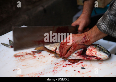 Uomo taglio di pesce al mercato del pesce di Catania, Sicilia, Italia Foto Stock