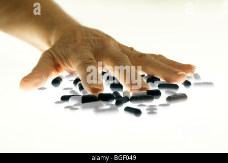 Senior donna di mano sulla pila di farmaci da prescrizione, studio shot Foto Stock