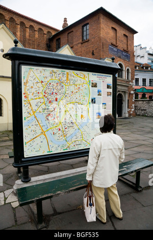 Persona che guarda una informazione di mappa stradale di Cracovia al di fuori della vecchia Sinagoga - Stara Synagoga - in Kazimierz, Cracovia. La Polonia. Foto Stock