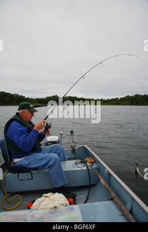 Senior anziani condito guida di pesca casting combattimenti combattendo il pesce luccio del nord Foto Stock