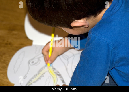 Un giovane bambino colorazione immagine del dinosauro. Foto Stock