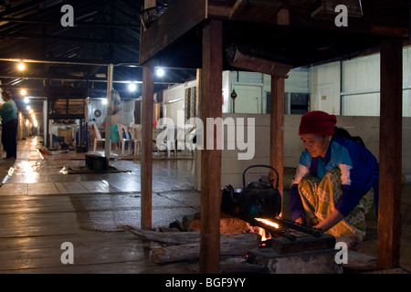 La gente per la cottura sul firepit del longhouse comunale del Barrio Asal nel Kelabit Highlands nel Borneo malese. Foto Stock