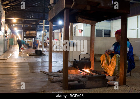 La gente per la cottura sul firepit del longhouse comunale del Barrio Asal nel Kelabit Highlands nel Borneo malese. Foto Stock