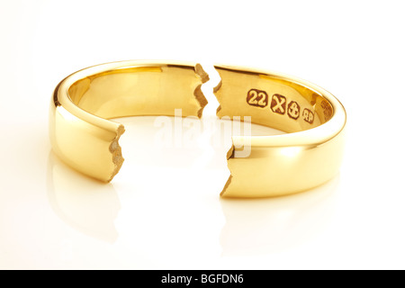 Oro rotto l'anello nuziale che simboleggiano il matrimonio si rompono Foto Stock