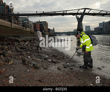 Gli uomini con i rivelatori di metallo sul fiume Tamigi. Foto Stock