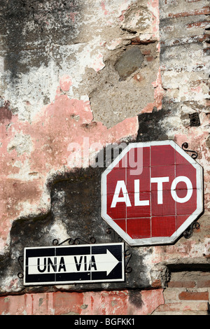 Arresto (alto) segno e un modo segno sulla Calle de los Pasos. Antigua Guatemala, America Centrale Foto Stock