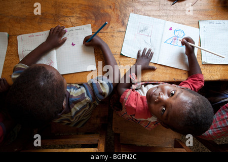 Ragazzi disegnare in un orfanotrofio nella regione di Kilimanjaro, Tanzania Africa Orientale. Foto Stock