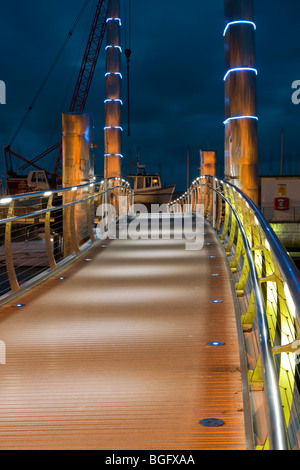 Piedi ponte sopra il porto di Torquay di notte Foto Stock