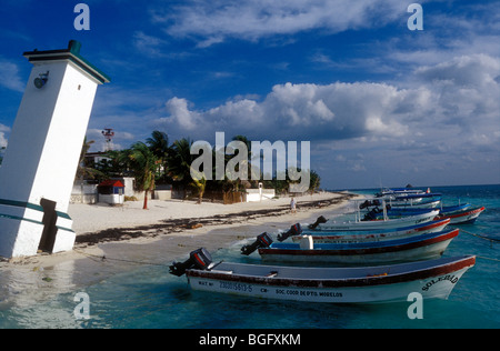 Barche da pesca e spiaggia con uragano torre danneggiata in Puerto Morelos, Quintana Roo, Messico Foto Stock