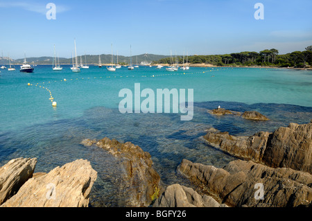 Plage d'Argent o sulla spiaggia con rocce & Yacht ormeggiati, Isola di Porquerolles, Îles Hyères, Var Costa Azzurra o la Costa Azzurra Francia Foto Stock